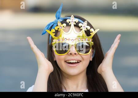 Lächelnd modische Teenager-Mädchen mit Stirnband und Sonnenbrille, Königin des Spaßes Konzept. Stockfoto