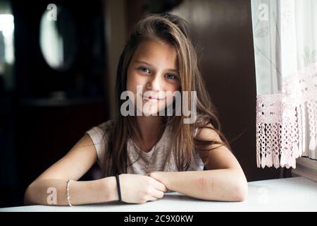 Portrait von niedlichen kleinen Mädchen am Tisch sitzen. Stockfoto