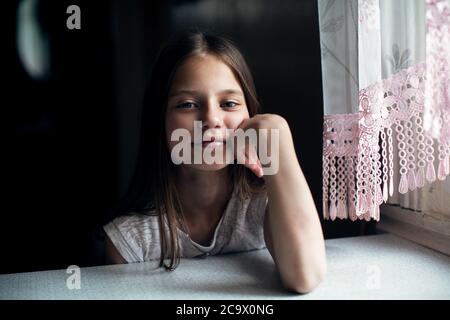 Сute kleines Mädchen sitzt am Tisch. Stockfoto