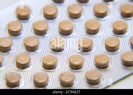 Blister mit Tabletten Nahaufnahme auf grauem Hintergrund. Pharmazeutischer oder medizinischer Hintergrund Stockfoto