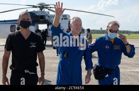 NASA-Astronaut Douglas Hurley winkt zu Zuschauern, als er an Bord eines Flugzeugs an der Naval Air Station Pensacola, um ihn und NASA-Astronaut Robert Behnken nach Hause nach Houston ein paar Stunden, nachdem das Duo landete in ihrem SpaceX Crew Dragon Endeavour Raumschiff vor der Küste von Pensacola, Florida, Am 2. August 2020. Der Demo-2-Testflug für das NASA Commercial Crew Programm war der erste, der Astronauten zur Internationalen Raumstation geliefert und an Bord eines kommerziell gebauten und betriebenen Raumschiffs sicher zur Erde zurückgebracht hat. Behnken und Hurley kehrten nach 64 Tagen im Weltall zurück. NASA Foto von Bill in Stockfoto