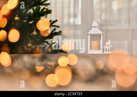 Silvester Weihnachtskomposition, Weihnachtsbaum, Kerze Laterne und Porzellan weißes Haus in märchenhaften warmen Lichtern. Stockfoto