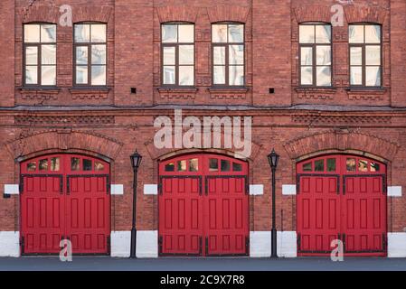 Feuerwehrhaus, ein altes historisches Backsteingebäude (1880er) mit roten Toren. Feuerwehr in Vasiljewski Insel, St. Petersburg, Russland. Stockfoto