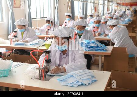 (200803) -- NANNING, 3. August 2020 (Xinhua) -- Arbeiter machen Masken bei einem lokalen Unternehmen im Bezirk Longlin, südchinesische Autonome Region Guangxi Zhuang, 22. April 2020. Guangxi, eine Schlüsselregion in Chinas Armutsbekämpfungsmission, unternimmt unermüdliche Anstrengungen, um den harten Kampf gegen die Armut zu gewinnen, indem sie die Beschäftigung der armen Bevölkerung sichert. Der Versuch, Menschen in Beschäftigung zu bringen, spielte eine entscheidende Rolle in Guangxi's groß angelegter Kampagne zur Bekämpfung der Armut, da sie die ganze Familie aus der Armut befreien kann. Es hat sich als der wirksamste und direkteste Weg erwiesen, die Armut zu überwinden. Darüber hinaus ist es h Stockfoto