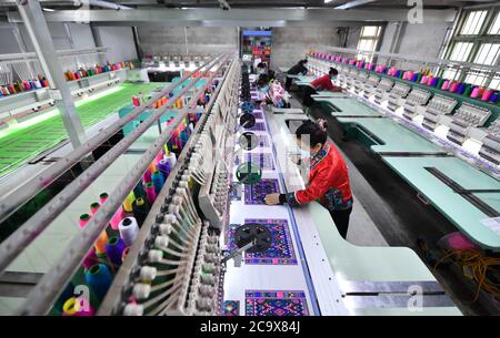 (200803) -- NANNING, 3. August 2020 (Xinhua) -- Arbeiter stellen Stickprodukte bei einem lokalen Unternehmen im Autonomen Bezirk Rongshui Miao, südchinesische Autonome Region Guangxi Zhuang, her, 13. März 2020. Guangxi, eine Schlüsselregion in Chinas Armutsbekämpfungsmission, unternimmt unermüdliche Anstrengungen, um den harten Kampf gegen die Armut zu gewinnen, indem sie die Beschäftigung der armen Bevölkerung sichert. Der Versuch, Menschen in Beschäftigung zu bringen, spielte eine entscheidende Rolle in Guangxi's groß angelegter Kampagne zur Bekämpfung der Armut, da sie die ganze Familie aus der Armut befreien kann. Es hat sich als der effektivste und direkteste Weg erwiesen, um zu helfen, zu schütteln Stockfoto