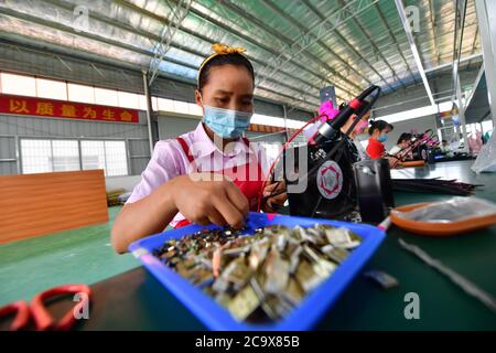 (200803) -- NANNING, 3. August 2020 (Xinhua) -- Mitarbeiter arbeiten an einer Produktionslinie eines Elektronikunternehmens im Bezirk Rongan, südchinesische Autonome Region Guangxi Zhuang, 17. Mai 2020. Guangxi, eine Schlüsselregion in Chinas Armutsbekämpfungsmission, unternimmt unermüdliche Anstrengungen, um den harten Kampf gegen die Armut zu gewinnen, indem sie die Beschäftigung der armen Bevölkerung sichert. Der Versuch, Menschen in Beschäftigung zu bringen, spielte eine entscheidende Rolle in Guangxi's groß angelegter Kampagne zur Bekämpfung der Armut, da sie die ganze Familie aus der Armut befreien kann. Es hat sich als der wirksamste und direkteste Weg erwiesen, die Armut zu überwinden. Stockfoto