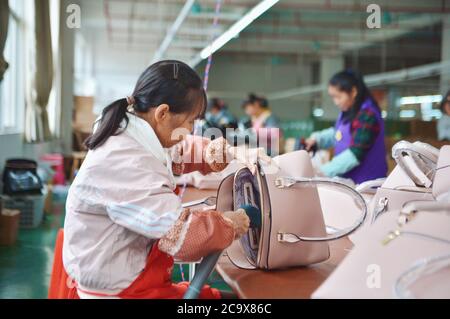 (200803) -- NANNING, 3. August 2020 (Xinhua) -- Arbeiter machen Lederhandtaschen im Bezirk Tiandeng, südchinesische Autonome Region Guangxi Zhuang, 28. November 2019. Guangxi, eine Schlüsselregion in Chinas Armutsbekämpfungsmission, unternimmt unermüdliche Anstrengungen, um den harten Kampf gegen die Armut zu gewinnen, indem sie die Beschäftigung der armen Bevölkerung sichert. Der Versuch, Menschen in Beschäftigung zu bringen, spielte eine entscheidende Rolle in Guangxi's groß angelegter Kampagne zur Bekämpfung der Armut, da sie die ganze Familie aus der Armut befreien kann. Es hat sich als der wirksamste und direkteste Weg erwiesen, die Armut zu überwinden. Darüber hinaus hat es Th gezeigt Stockfoto