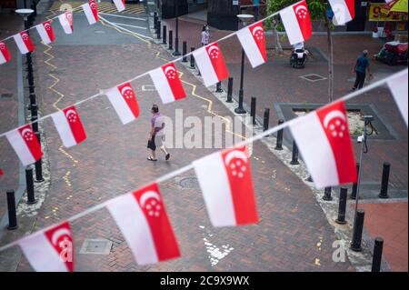 16.07.2020, Singapur, Republik Singapur, Asien - kleine Flaggen in den Nationalfarben des Stadtstaates, die als Wimpelbanner über der Straße schweben. Stockfoto