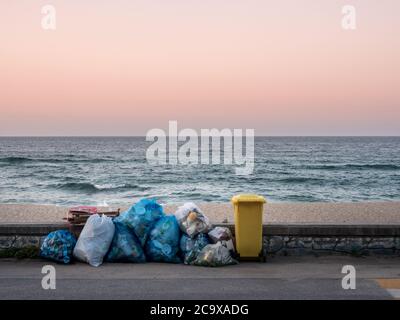 Gangneung, Provinz Gangwon, Südkorea - EIN Müllhaufen und Mülleimer am Strand in Sacheon Beach. Sonnenuntergang am Himmel. Abenddämmerung. Ein Müllhaufen und Abfalleimer. Stockfoto