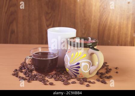 Kaffeetassen mit Kaffeebohnen auf dem Tisch. Stockfoto