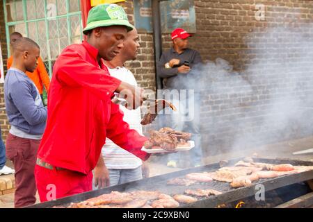 Mann macht oder Kochen gegrilltes Rindfleisch in SOWETO in Johannesburg Stockfoto