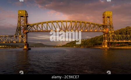 Sonnenuntergang über der erhöhten Eisenbahnbrücke über den Second Narrows von Burrard Inlet und Vancouver Harbour Stockfoto