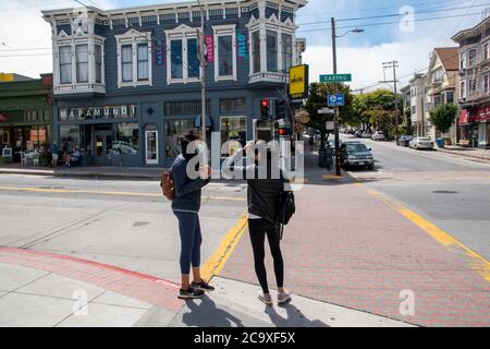 Frauen warten darauf, an einer Kreuzung im Noe Valley Viertel von San Francisco, CA, USA, die Straße zu überqueren. Stockfoto