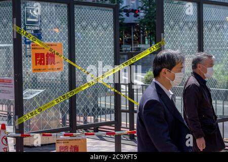 7. Mai 2020, Tokio, Japan: Arbeiter mit Gesichtsmasken als vorbeugende Maßnahme gehen inmitten der Coronavirus-Krise auf die Straße der zweimonatige Ausnahmezustand, der von der japanischen Regierung als Reaktion auf die COVID-19-Pandemie ausgerufen wurde, endete am 1. Juni. Obwohl Japan die hohen Infektionen und Sterblichkeitsraten einiger Länder während der ersten Krisenwelle vermieden zu haben scheint, wurden in vielen Gebieten in Tokio und im ganzen Land Geschäfte geschlossen und geschlossen. Die Absage der Olympischen Spiele 2020 in Tokio und eine steigende Zahl von Infektionen, da die Menschen wieder zu einem normaleren Leben nach der ging Stockfoto