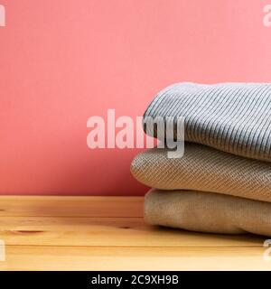 Haufen warmer Pulli Kleidung auf Holztisch. Herbst- und Winterkonzept. Mit Kopierfläche Stockfoto