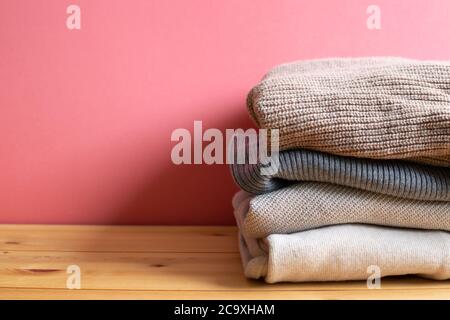 Haufen warmer Pulli Kleidung auf Holztisch. Herbst- und Winterkonzept. Mit Kopierfläche Stockfoto