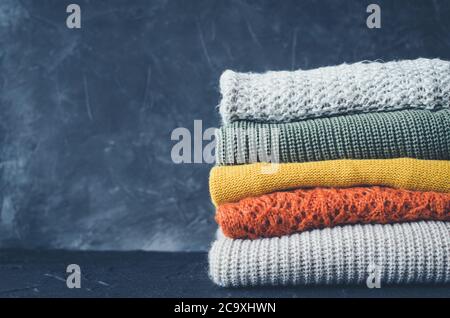 Stapel aus Gewirken aus Wolle pullover Herbst Farben. Kleidung mit verschiedenen Strickmuster im Stapel gefaltet. Warmen gemütlichen Winter fallen Strickwaren Konzept. Kopieren Stockfoto