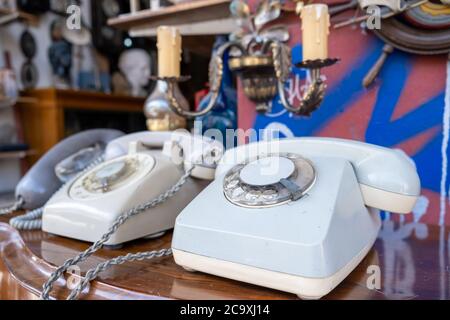 Telefon Vintage zum Verkauf in einem Flohmarkt . Altmodische Retro-Telefon-Geräte auf einem Holztisch, Nahaufnahme, verwischen antiken Hintergrund speichern Stockfoto