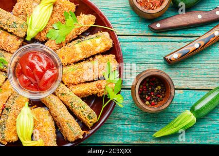 Gebackene Zucchini-Sticks mit Saucen, geröstete Zucchini.paniert gebratene Zucchini.Vegan Essen Stockfoto