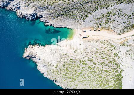 Küstenlinie an der Adria in Kroatien, schöner geheimer Strand zwischen Steinklippen in der Nähe der Stadt Vrsi, Luftaufnahme von oben Stockfoto