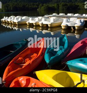 Reihen von Tretbooten zu vermieten entlang einem hölzernen Ponton, Lake Chambon, Puy de Dome, Auvergne, Frankreich Stockfoto