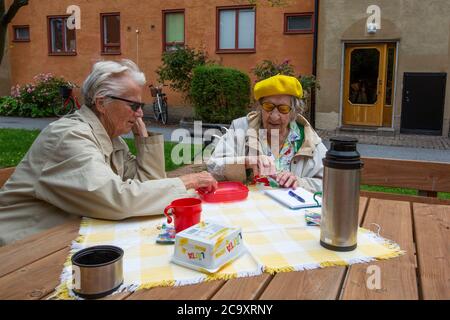 Ältere Damen spielen ein Brettspiel draußen im Garten. Stockfoto