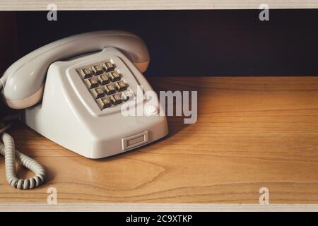 Alte Vintage-Telefon mit Draht auf Holzregal, Retro-Design-Nahaufnahme Nostalgie Stockfoto