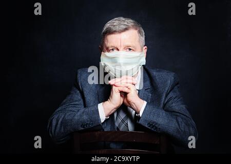 Zuversichtlich Reifen Geschäftsmann in medizinischen Schutz Gesichtsmaske auf schwarz Stockfoto