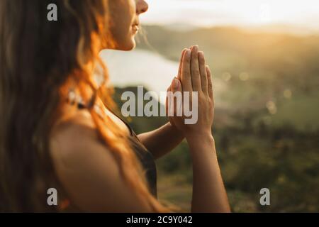 Frau alleine beten bei Sonnenaufgang. Natur Hintergrund. Spirituelle und emotionale Konzept. Sensibilität für die Natur Stockfoto