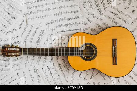 Alte klassische Gitarre, die auf Noten liegt Stockfoto