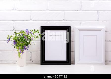 Zwei schwarz-weiße Rahmen mit mattem Mockup mit violettem Vogelvetch in der Zylindervase. Leerer Posterrahmen für Präsentationsgestaltung. vorlagenframi Stockfoto