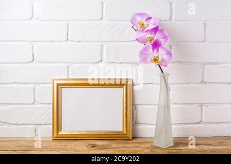 Gold verzierte Landschaft, Rahmen Mockup mit rosa Orchidee in der matten Glasvase. Leerer Rahmen für Präsentationsgrafiken. Schablonenrahmen für Mo Stockfoto