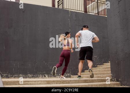 Junge Paar Athleten laufen oben auf der Suche nach Gesundheit und Erfolg. Freunde Läufer beim morgendlichen Training auf City-Training Ausdauer. Erfolg A Stockfoto