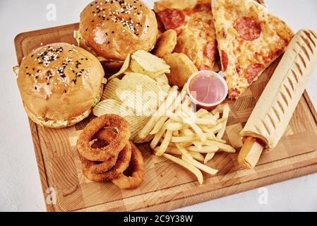 Ungesunde und Junk-Food. Verschiedene Arten von Fast Food auf dem Tisch, Nahaufnahme Stockfoto