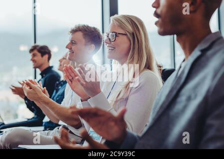 Gruppe von Geschäftsmännern und Geschäftsfrauen, die während einer Präsentation im Publikum klatschen. Geschäftsleute applaudieren in einer Konferenz. Stockfoto