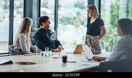 Gruppe von glücklichen Firmenleuten in einem Meeting. Geschäftsmann und -Frau diskutieren Geschäft in Büromeeting. Stockfoto