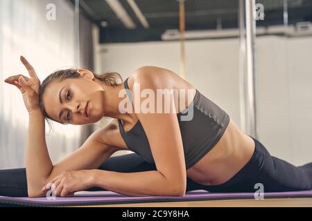 Attraktive junge Frau macht die Splits im Studio Stockfoto