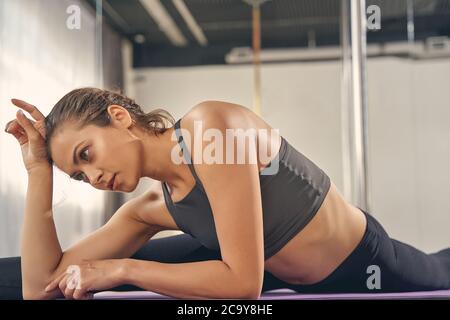 Charmante junge Frau tut die Splits im Studio Stockfoto