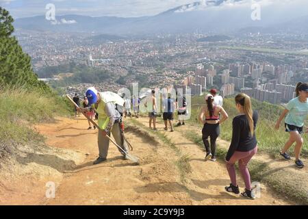 MEDELLIN, KOLUMBIEN - 26. Jan 2020: Herr Favio baut freiwillig eine Schottertreppe auf dem Hügel 'Las tres cruces' in Medellin, während die Bürger zum Sport gehen Stockfoto