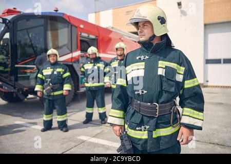 Fröhlicher Mann trägt Schutzuniform und Helm Stockfoto