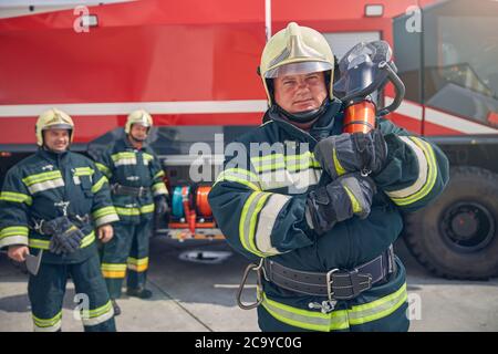 Porträt eines selbstbewussten Feuerwehrmuners mit männlichen Kollegen in der Feuerwehr Stockfoto