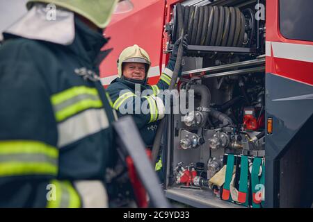 Reife Feuerwehrausbildung Arbeit mit Feuerausrüstung Stockfoto