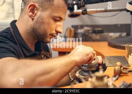 Fokussierter junger Mann, der in einem Studio arbeitet Stockfoto