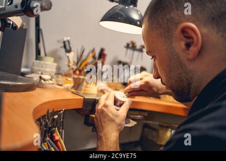 Mann, der an einem neuen Schmuckstück arbeitet Stockfoto