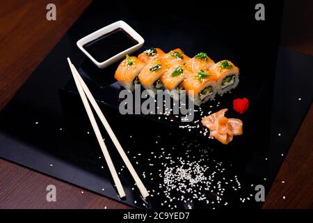 Sushi mit Lachs. Sojasauce, Ingwer, roter Kaviar. Rollen mit roten Fischen. Stockfoto