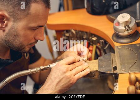 Männlicher Juwelier, der mit einem Handwerkzeug arbeitet Stockfoto