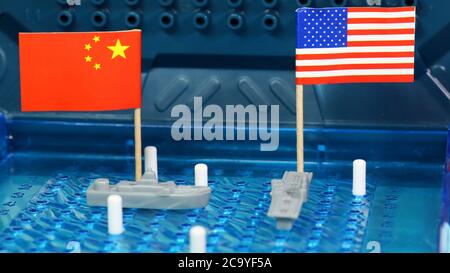 American, U.S., USA United States of American Naval Navy Kriegsschiff Treffen Sie chinesische Marineschiff auf einem Battleship Board Spiel. Nationalflaggen. Umstrittener Südchin Stockfoto