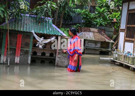 Munshiganj, Bangladesch. August 2020. Eine Frau geht durch das Hochwasser in Munshiganj. Ein Drittel von Bangladesch ist unter Wasser, nachdem einige der schwersten Regenfälle seit einem Jahrzehnt mehr als 3 Millionen Menschen mit Häusern und Straßen in Dörfern überflutet verlassen, sagten Beamte des Hochwasserprognosen- und Warnzentrums (FFWC). Kredit: SOPA Images Limited/Alamy Live Nachrichten Stockfoto