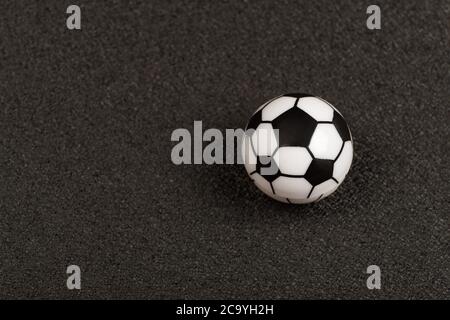 Kleiner Spielzeugfußball auf schwarzem Hintergrund. Nahaufnahme Stockfoto
