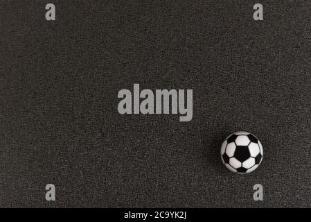 Kleiner Fußball auf schwarzem Hintergrund. Speicherplatz kopieren. Modell. Stockfoto